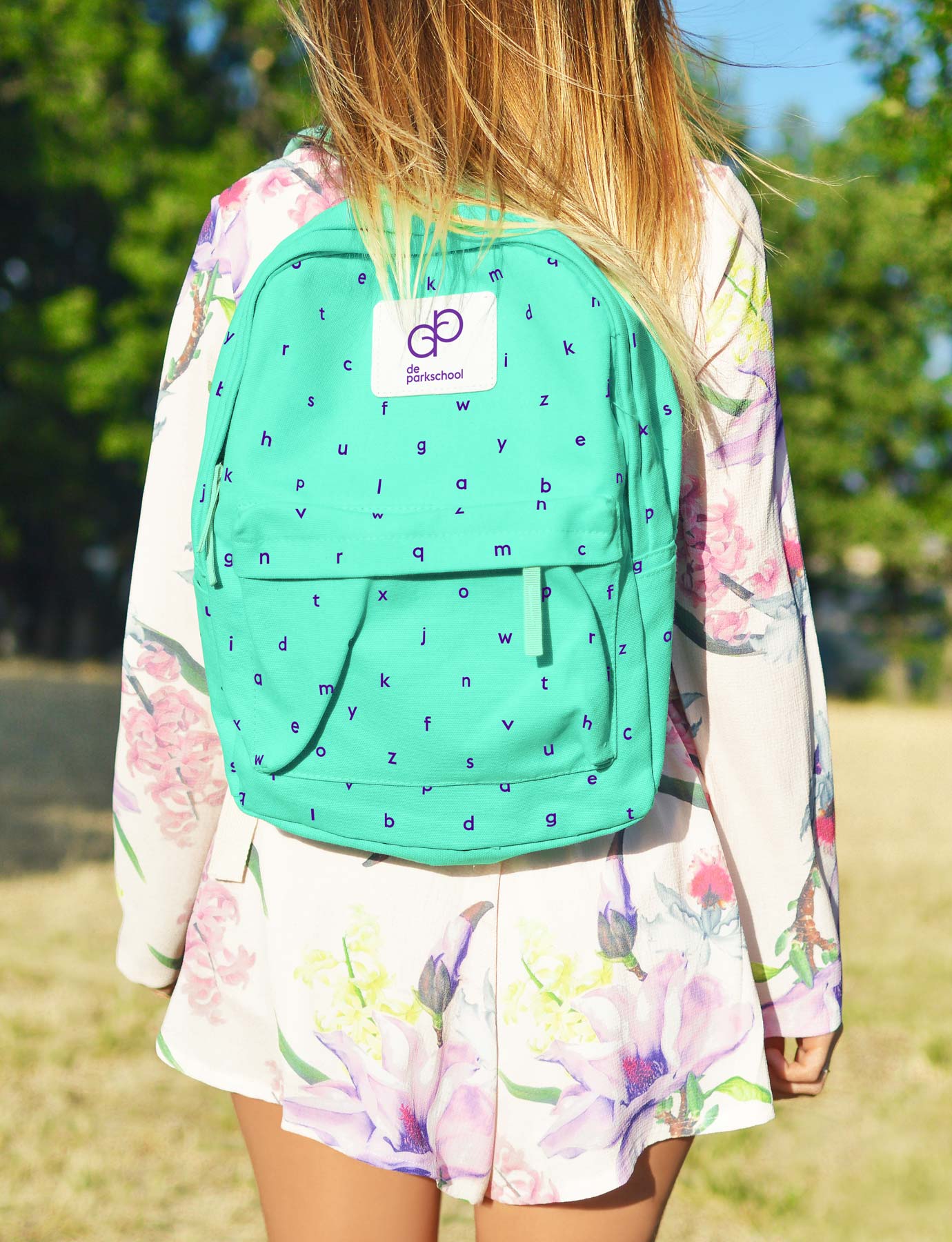 child wearing a backpack covered with letters